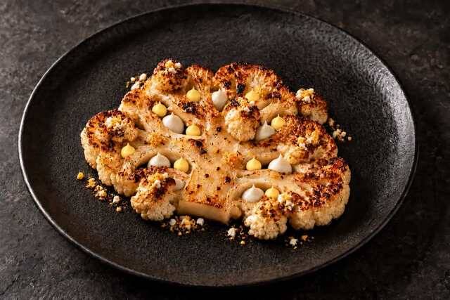 Blumenkohlsteak mit gerösteten Röschen und knusprigem Crumble