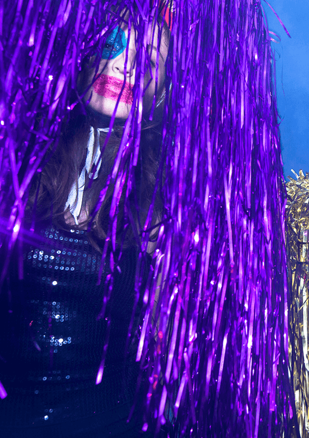 Person with colorful makeup covered in purple glitter