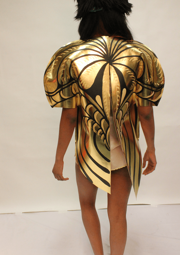 Person with black hat wearing golden beetle costume