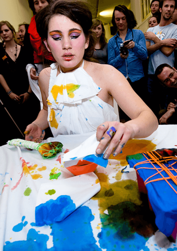 Girl in white dress playing with colorful paint 