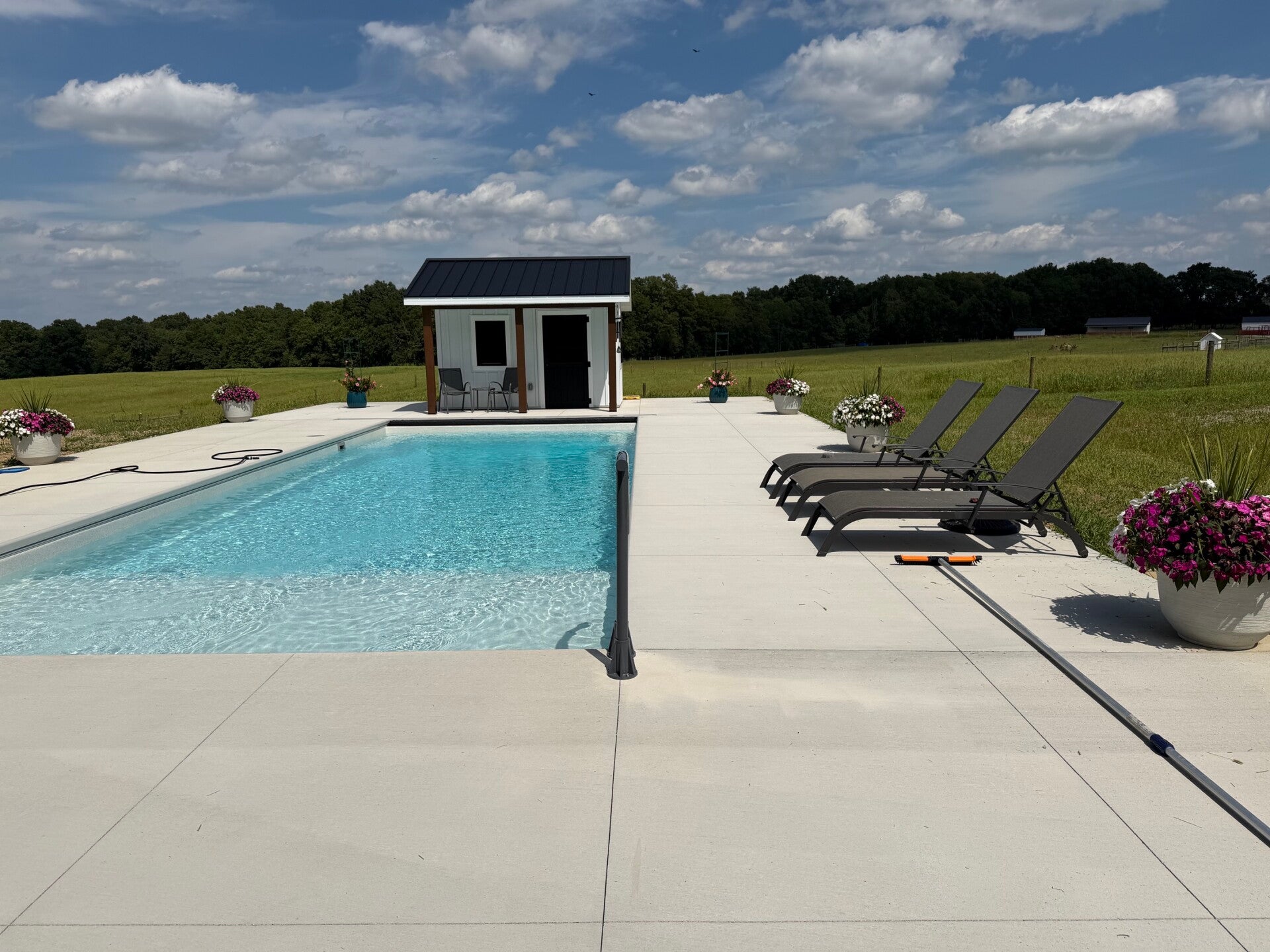 Completed Rainbow Pools fiberglass pool installation with a surrounding patio