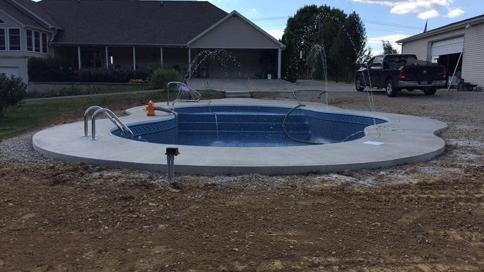 A rounded pool shape with a sweeping concrete surround.