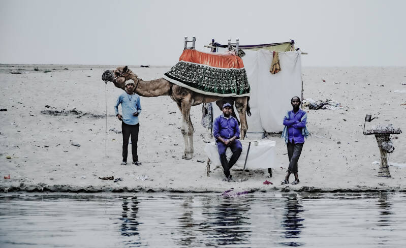 Street photography India: camel guides along Ganges river