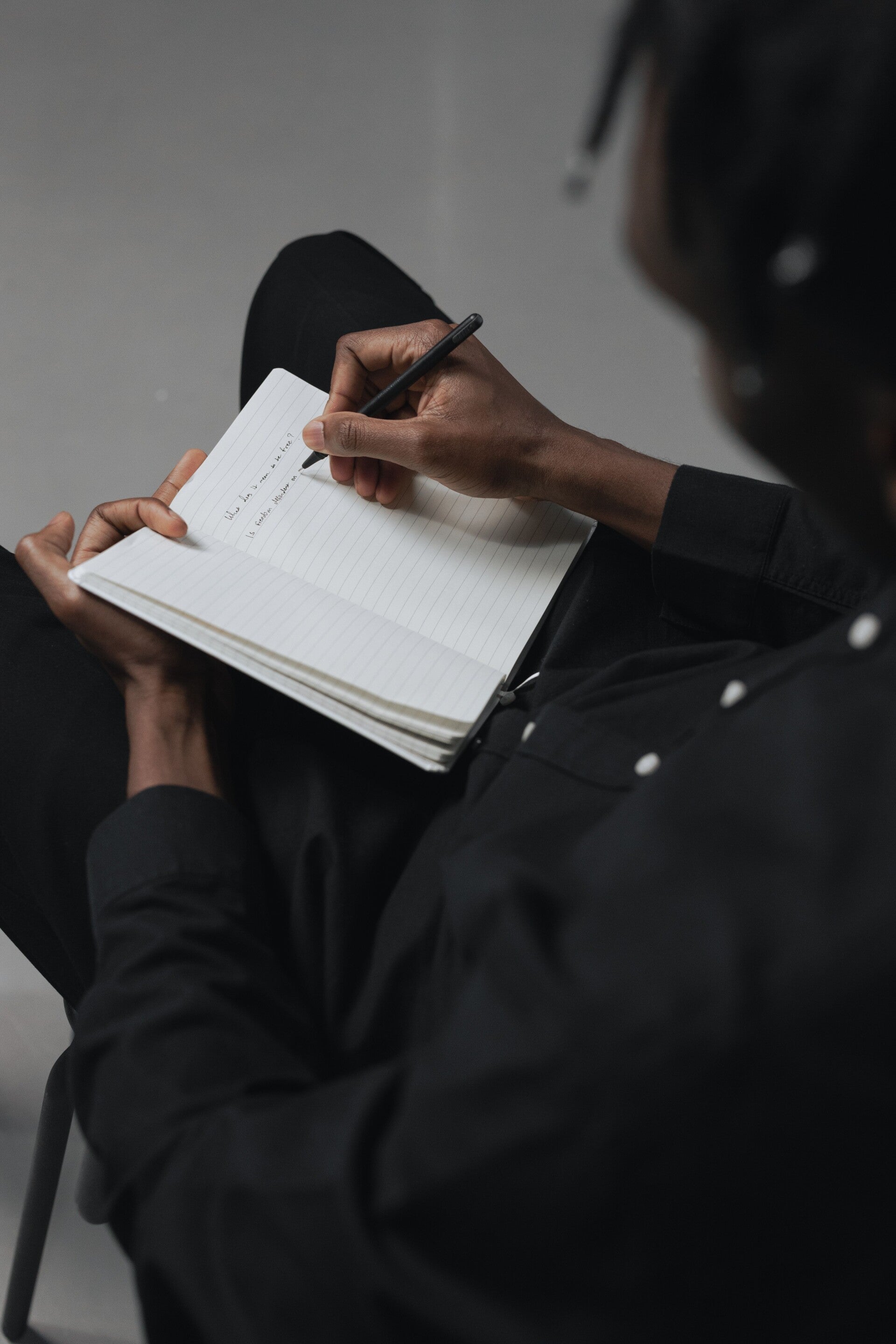 personne qui écrit dans un carnet ce qu'il voit autour de lui