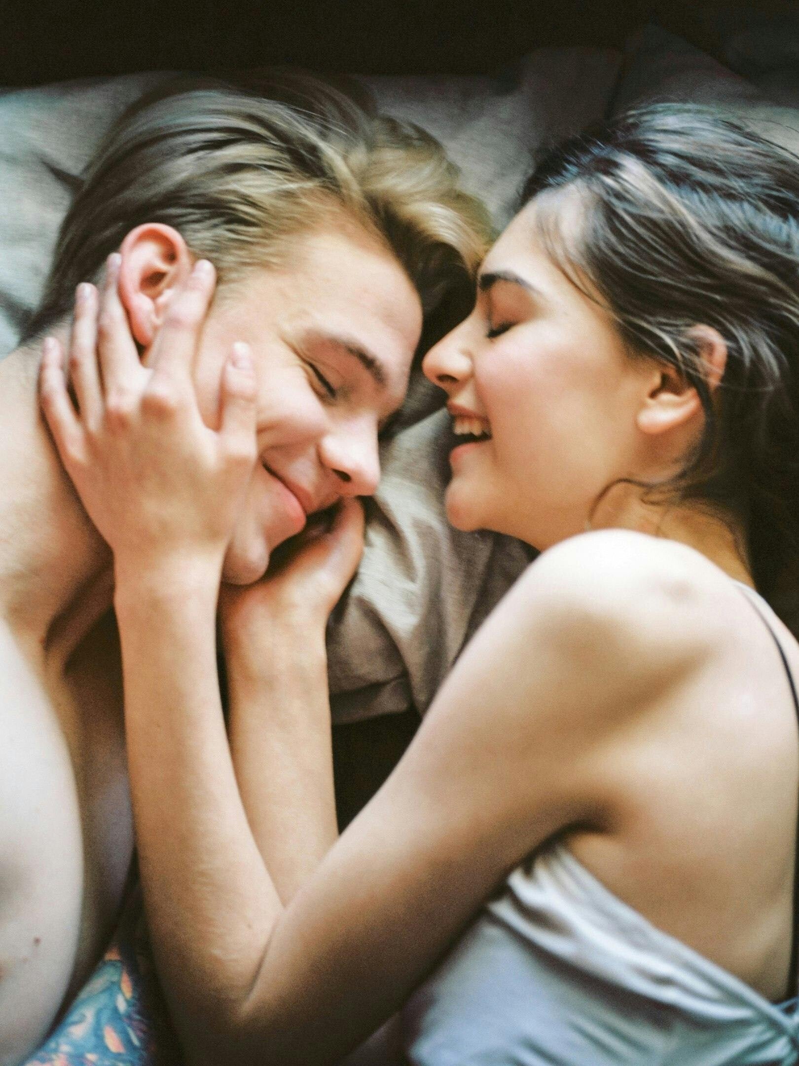 couple dans un lit qui rit ensemble