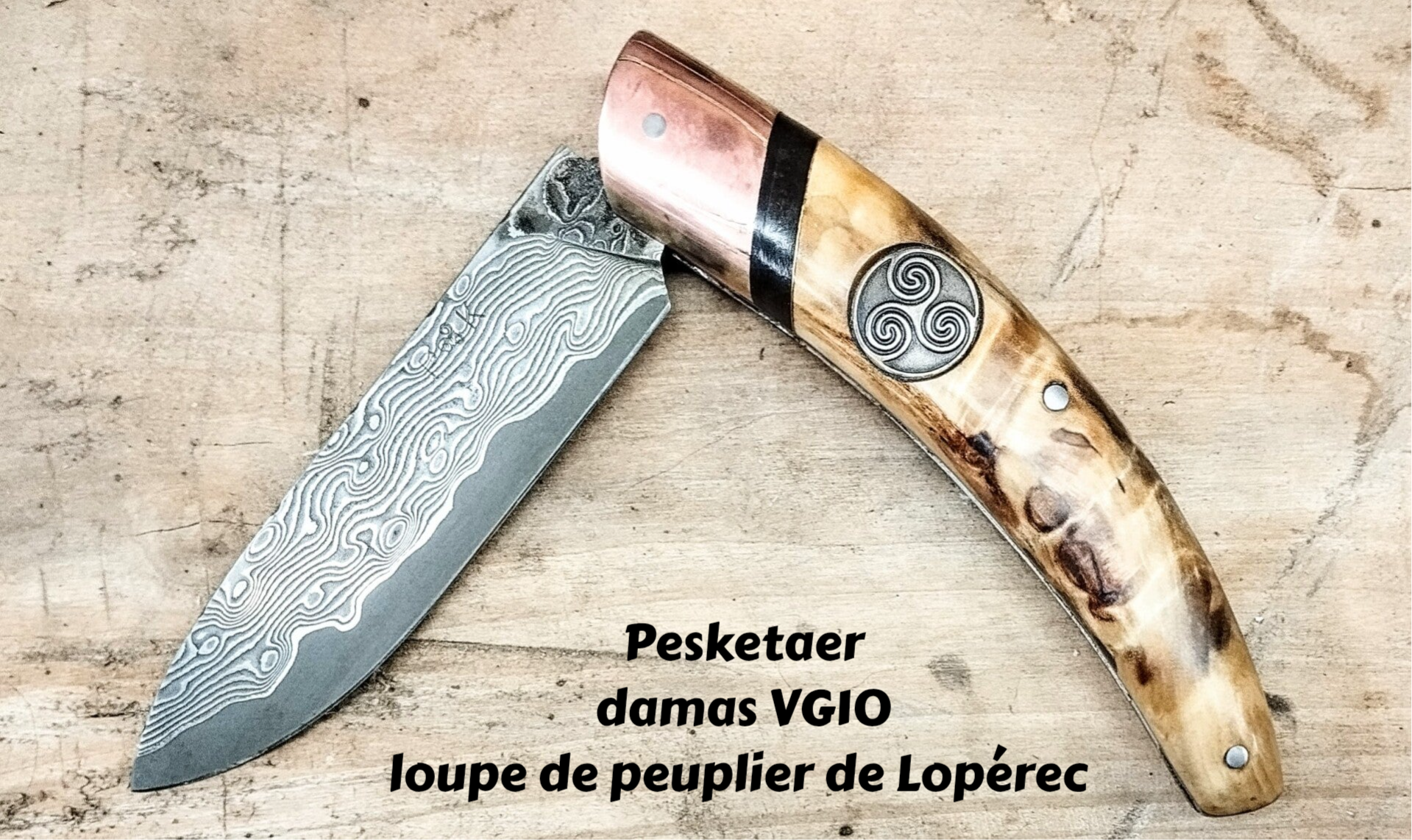 Couteau pliant portant un triskell incrusté dans le manche en loupe de peuplier, avec une lame en damas type japonais 