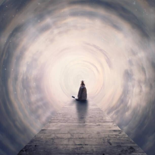 Eine orangefarbene getigerte Katze steht in einer Wolkenlandschaft und blickt auf einen antiken, steinernen Torbogen, durch den helles Licht scheint, im Kontext mit Jenseitskontakte Jana Lorenz.