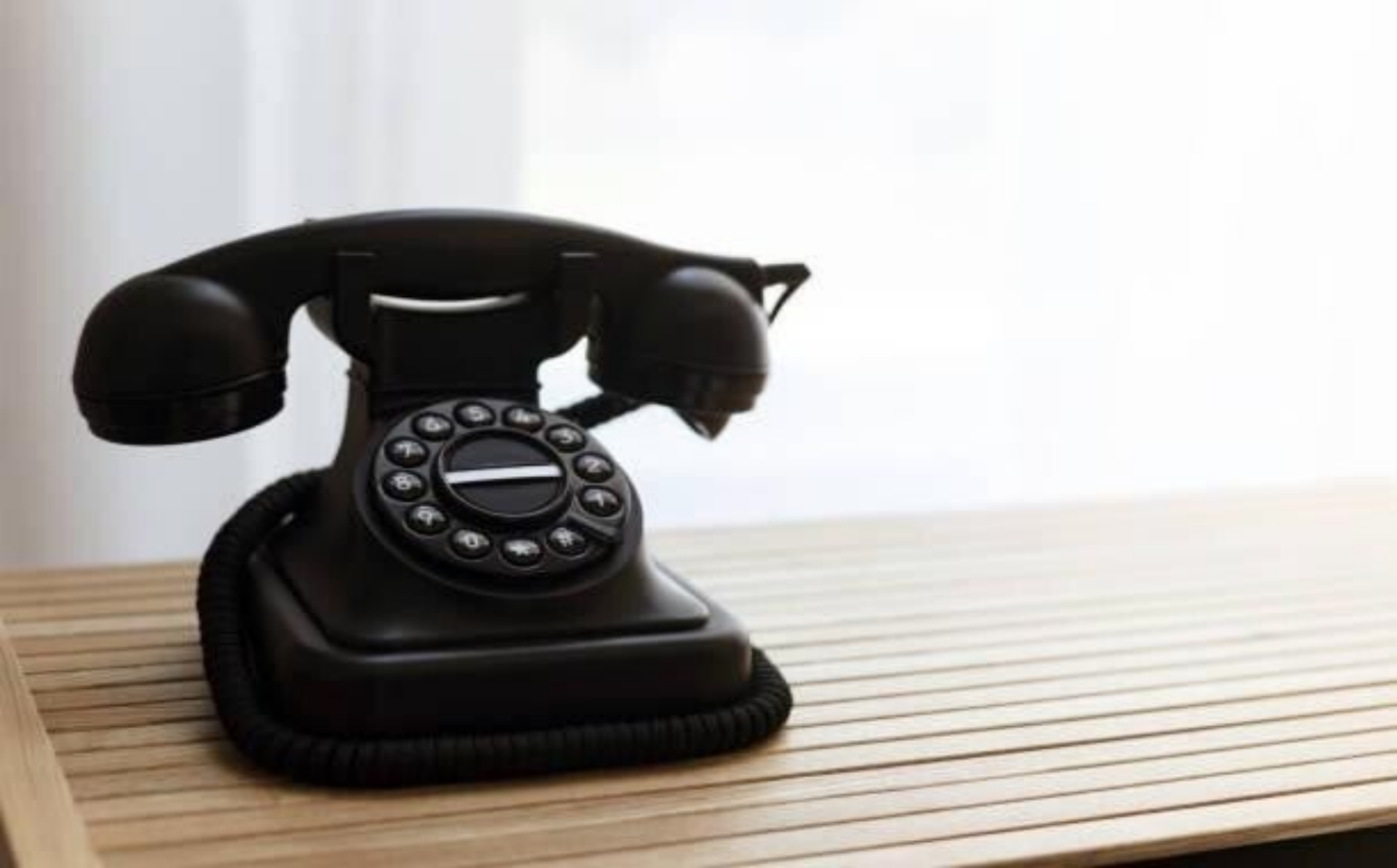 Ein vintage Telefon liegt auf einem Holztablett, das die Eleganz und den Charme vergangener Zeiten widerspiegelt, im Kontext mit Jenseitskontakte Jana Lorenz.