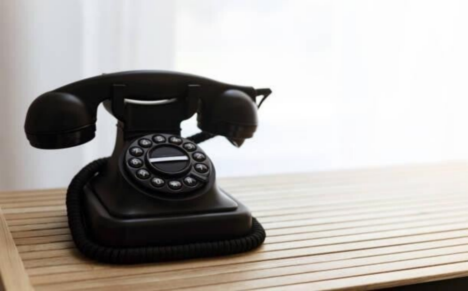 Ein vintage Telefon liegt auf einem Holztablett, das die Eleganz und den Charme vergangener Zeiten widerspiegelt, im Kontext mit Jenseitskontakte Jana Lorenz.