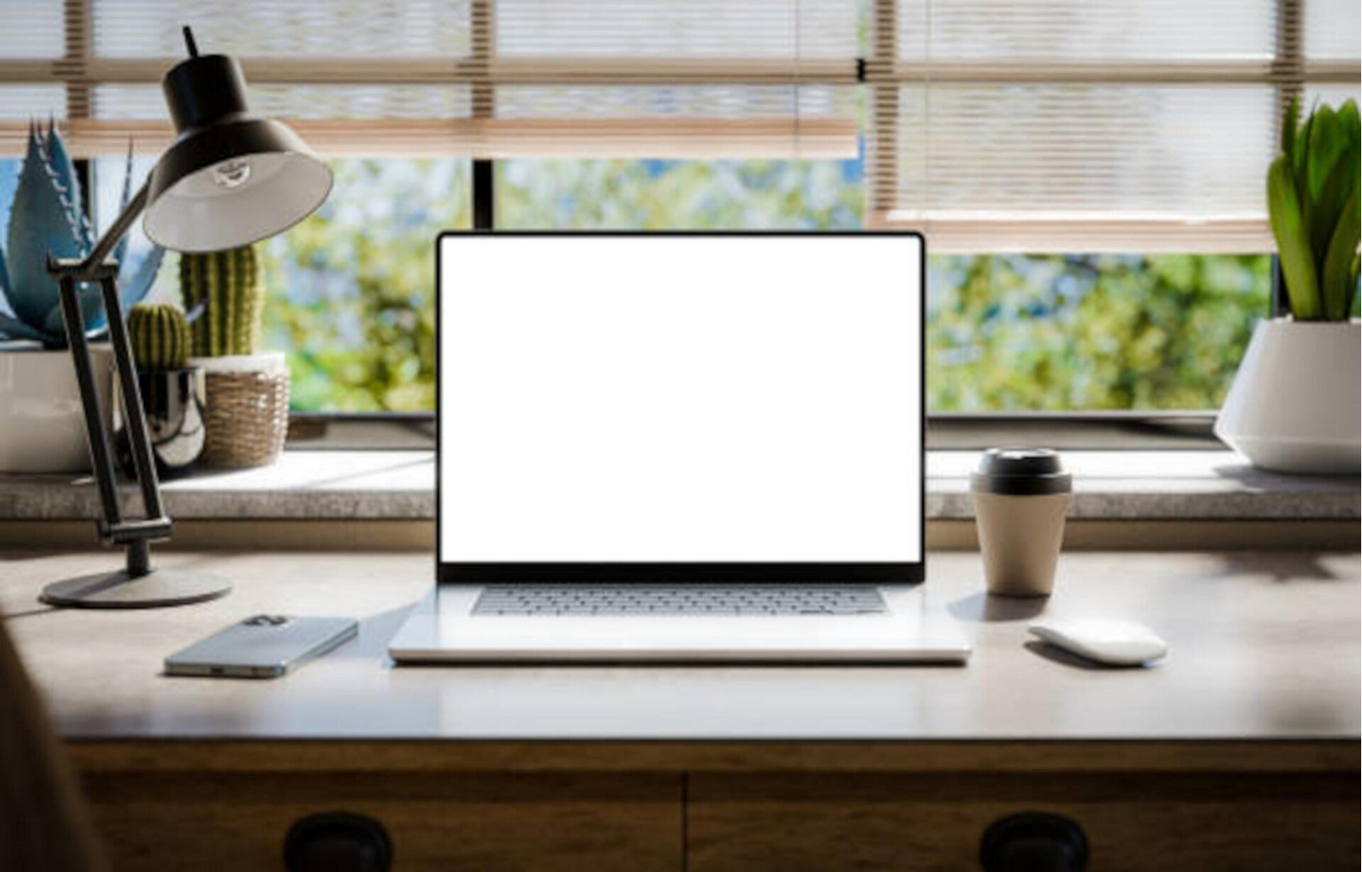 Arbeitsplatz mit aufgeklapptem Laptop, Notizbuch mit Stift, Kaffeetasse, Schreibtischlampe und Pflanzen vor einem Fenster mit Regentropfen und unscharfen Lichtern im Hintergrund, im Kontext mit Jenseitskontakte Jana Lorenz.