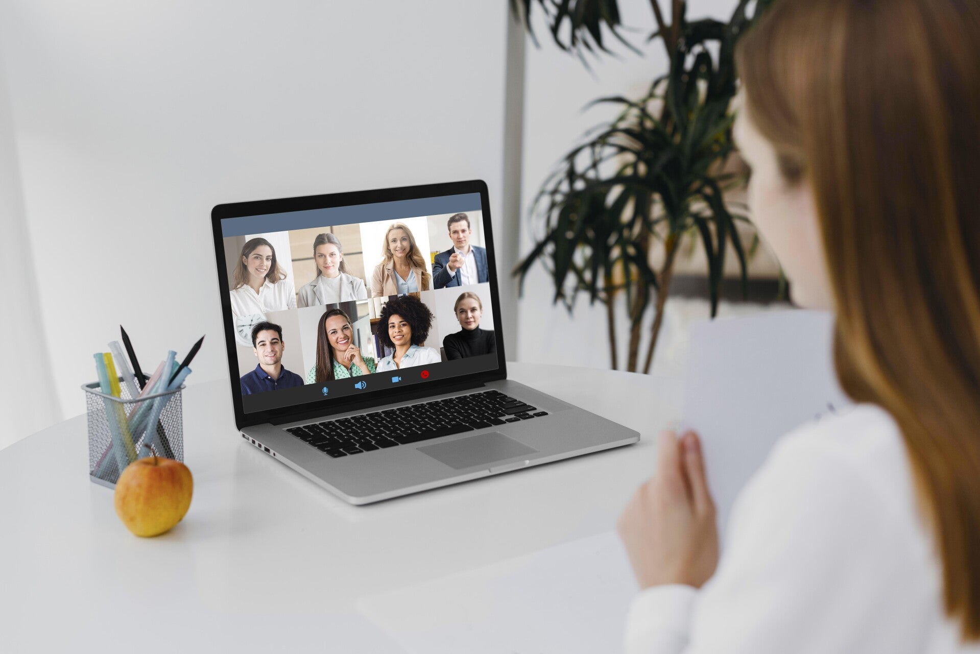 Person sitzt vor einem Laptop mit einer Online-Video-Konferenz, auf dem Bildschirm sind mehrere Teilnehmer in Kacheln zu sehen, im Kontext mit Jenseitskontakte Jana Lorenz.