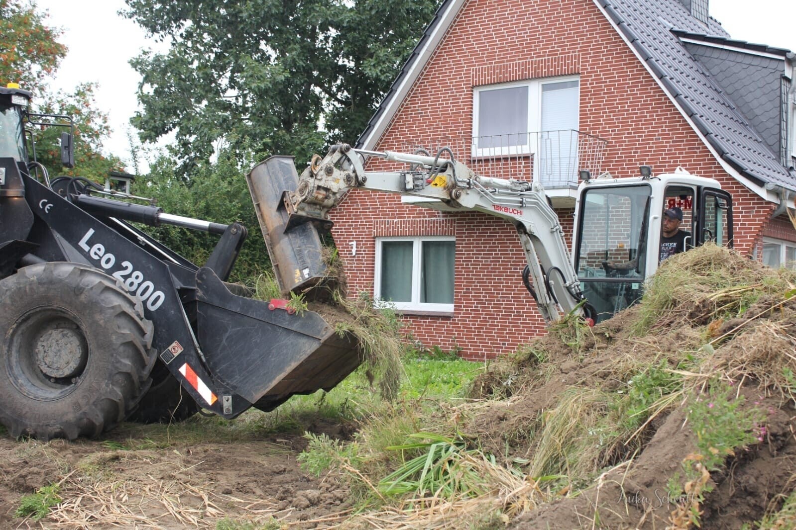 Erdarbeiten mit Bagger und Lader auf einem Grundstück