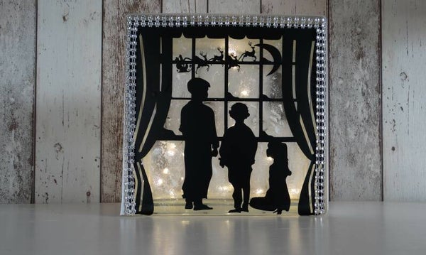 Prachtig verlichte glasdal met gezin voor het raam