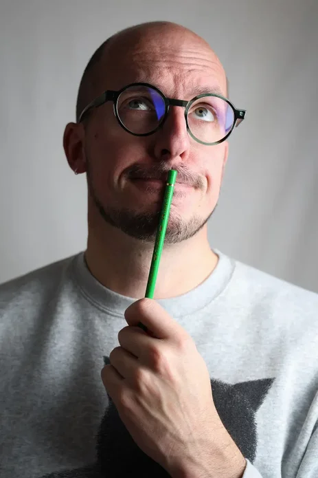 Illustrator Henk van der Gugten met een groene potlood