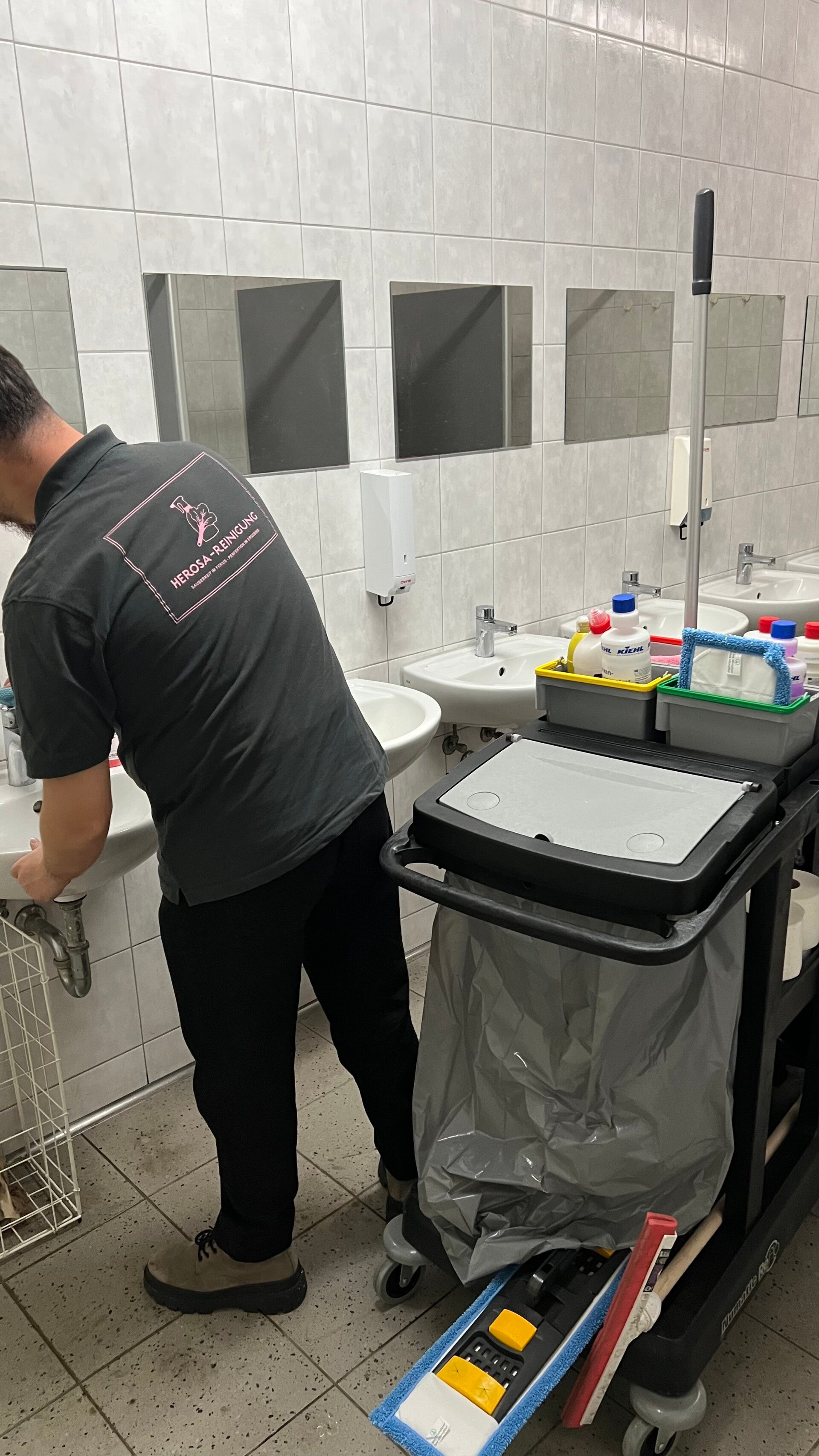Mitarbeiter von HEROSA Facility Services bei der professionellen Unterhaltsreinigung eines Sanitärbereichs