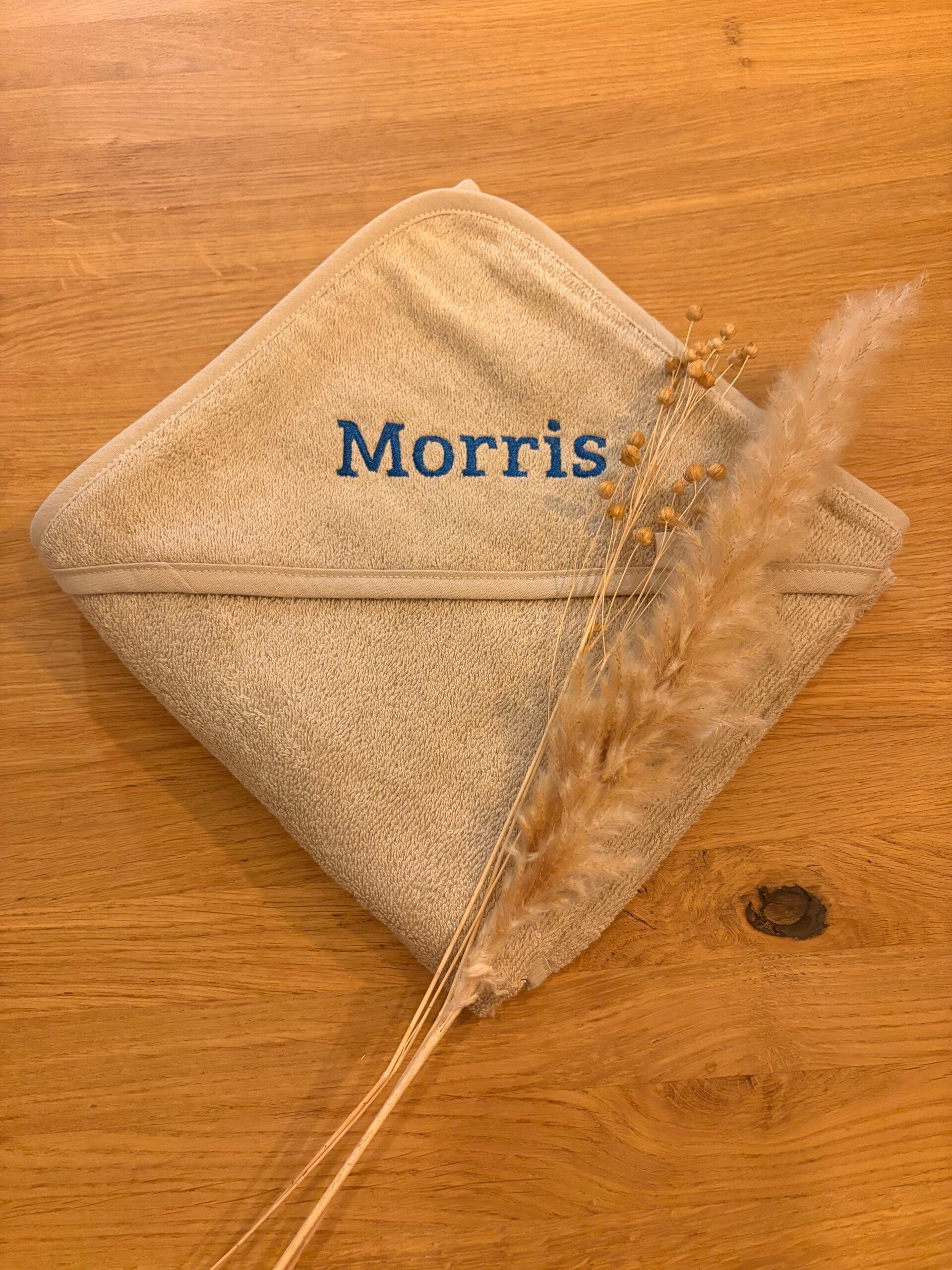 Zandkleurige badcape met de naam Morris geborduurd in blauwe letters