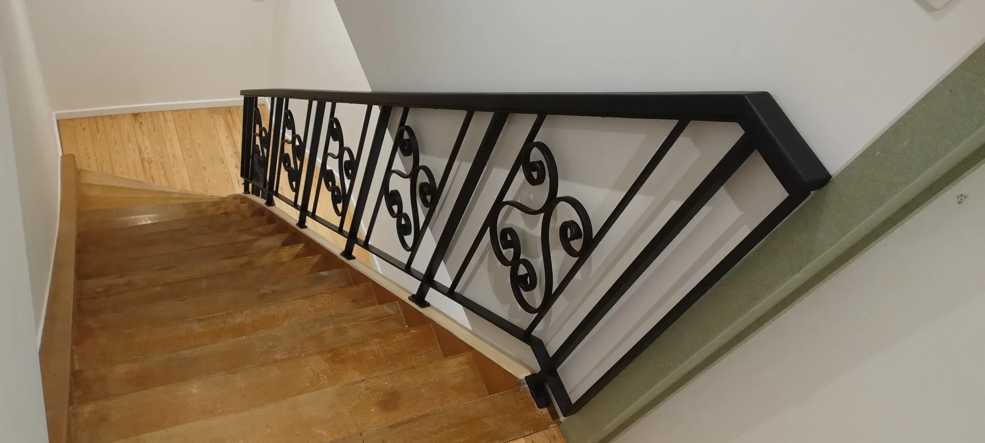 Stalen  trapbalustrade in klassiek smeedwerk, zwar gelakt.