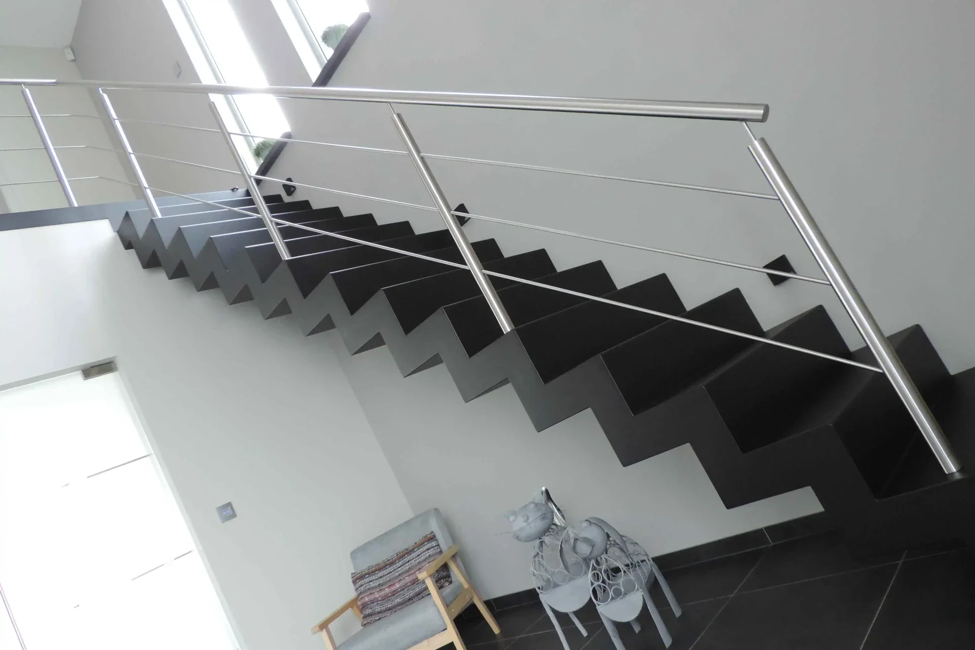 Rechte metalen bloktrap met inox trapleuning.