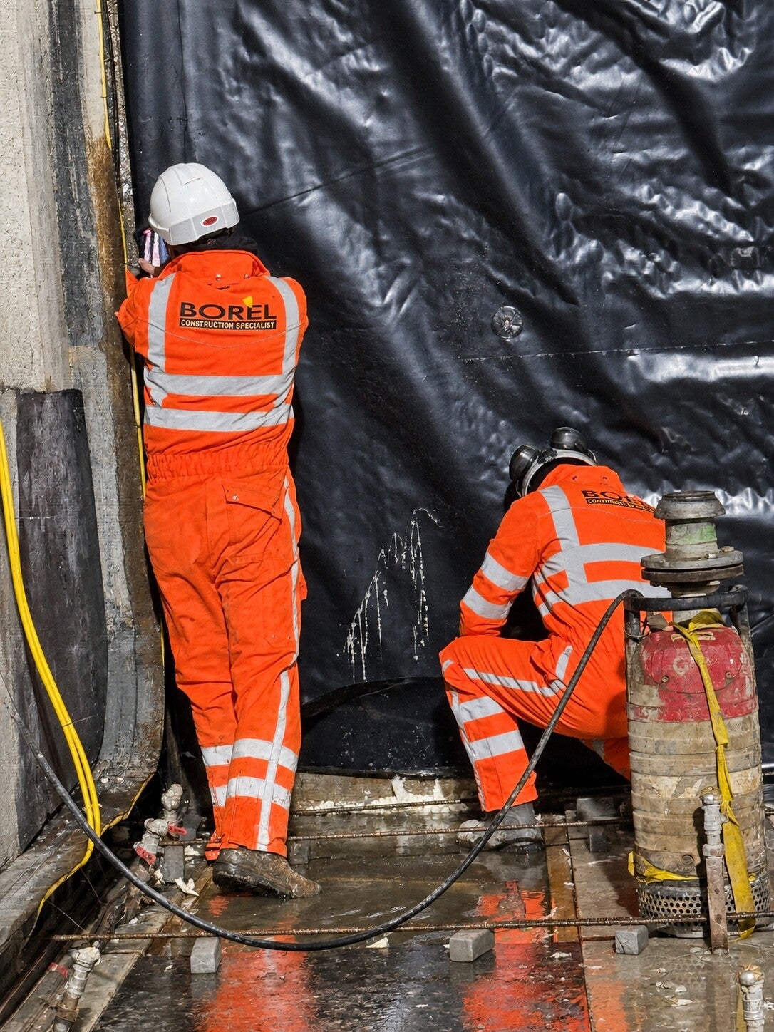 Two BORÈL specialists carrying out injection work on a sealed concrete wall