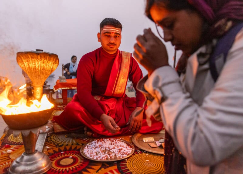 A devotee requesting blessing from a priest in Varansi