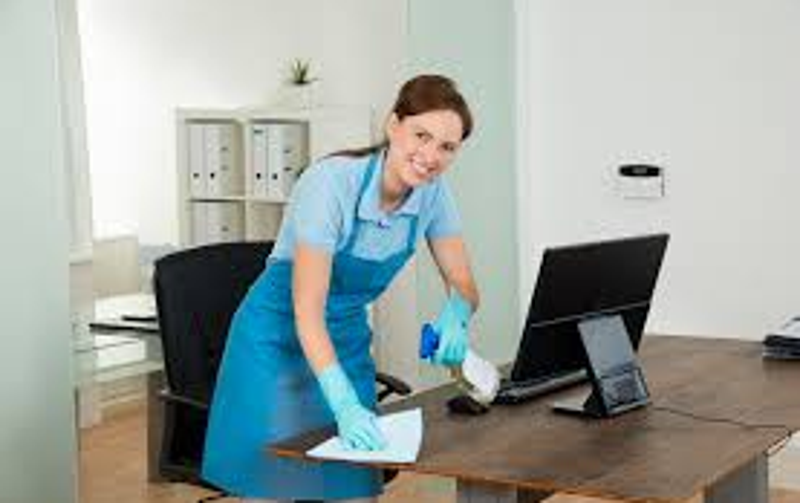 "Cleaner wiping down a computer desk in a small home office during a one-off domestic clean in Telford – detailed surface sanitisation by Bright Starz.