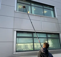 Bright Starz operative cleaning shopfront and upper windows on a commercial property in Telford using a Water Fed Pole system – professional and safe window cleaning service.