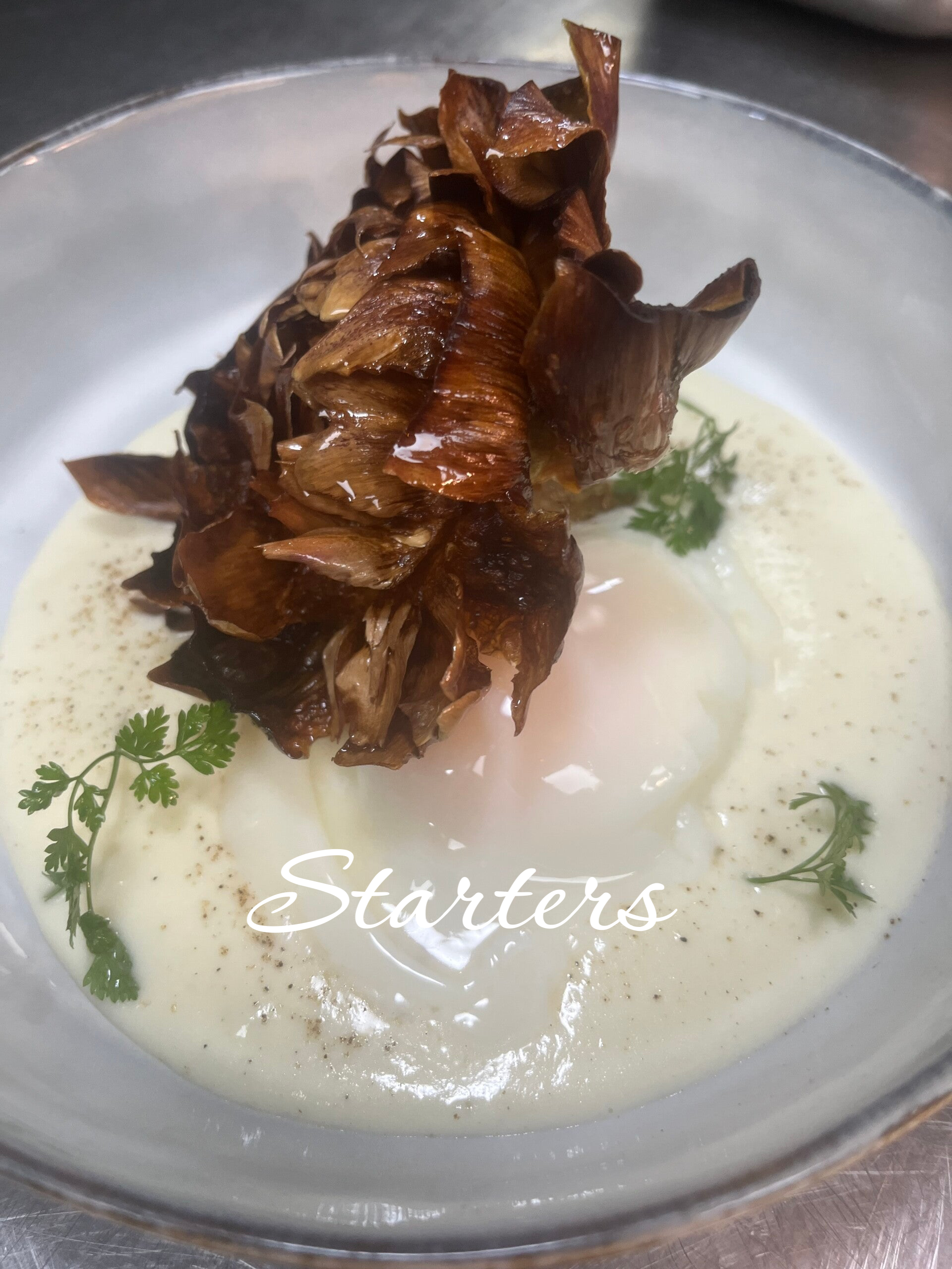 Gourmet starter with crispy artichoke and light cream, signature appetizer for luxury private dining events.