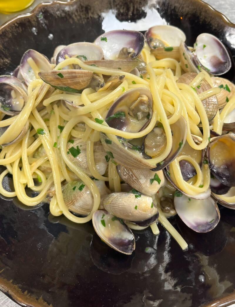 Gourmet Italian linguine with fresh clams and seafood reduction, premium private chef pasta course.