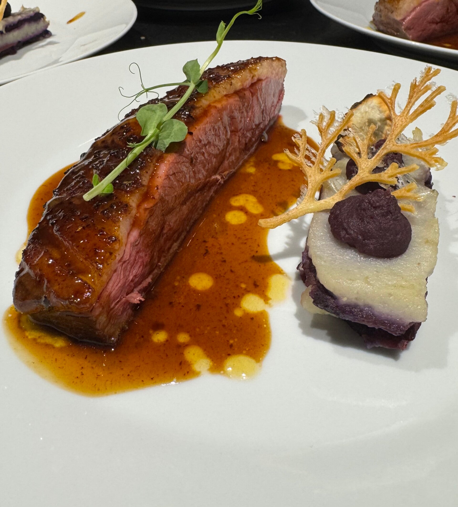 Crispy skin duck breast with vibrant purple sweet potato, sunchokes, and a glossy yuzu-infused beef jus, luxury private chef main course.