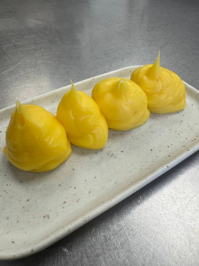 Smooth and glossy gourmet lemon cream being prepared in a professional high-end kitchen, luxury pastry and fine dining dessert components.