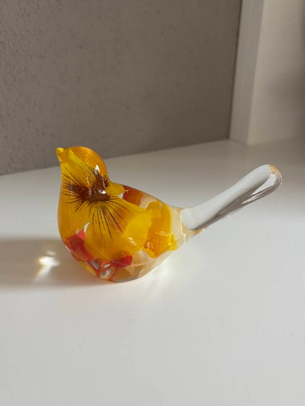 Decoratieve vogel in transparant met ingegoten kunstbloemen in geel/oranje