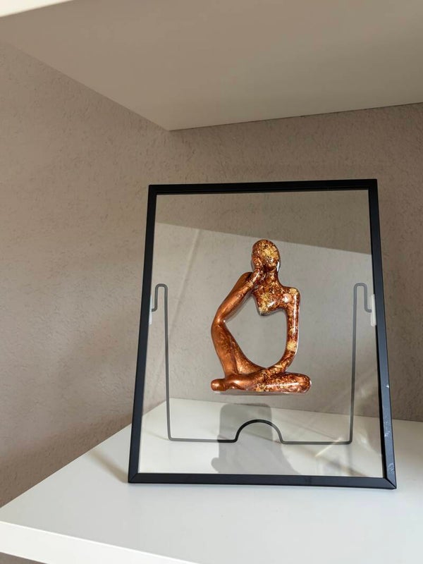 Beeldje “denker” in zwarte fotolijst