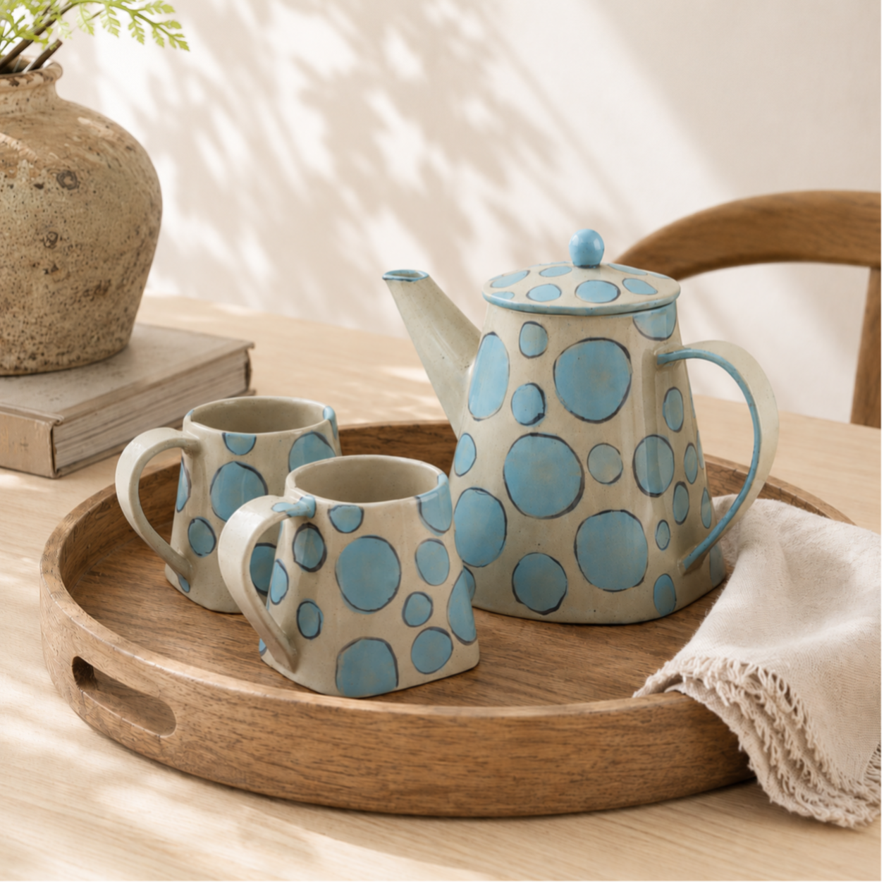 Theepot met twee mokken creme met blauwe stippen