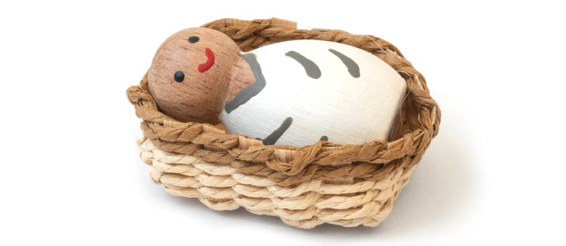 Houten babypoppetje in mozesmandje