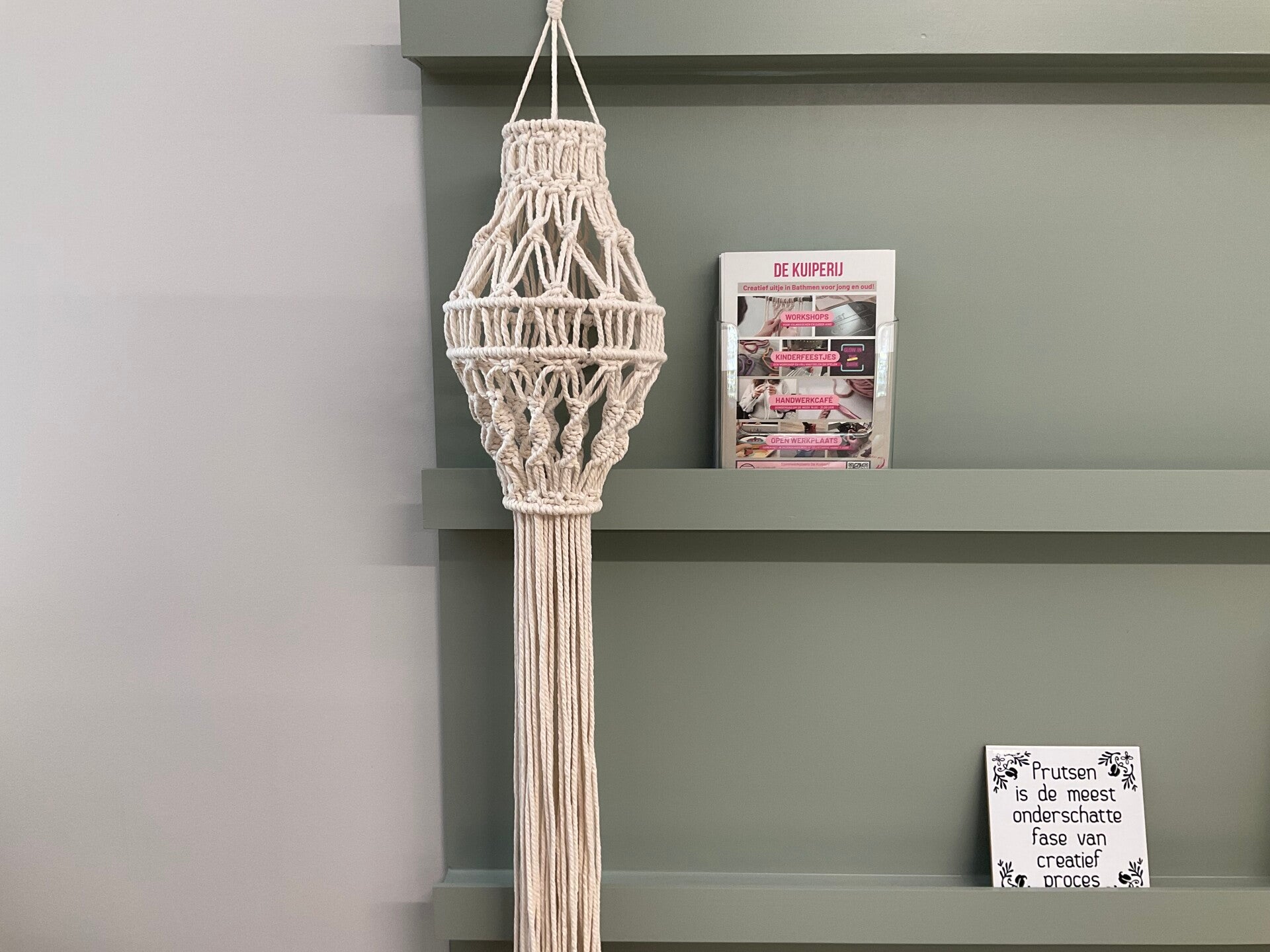 Een ecru macramé lantaarn die buiten hangt