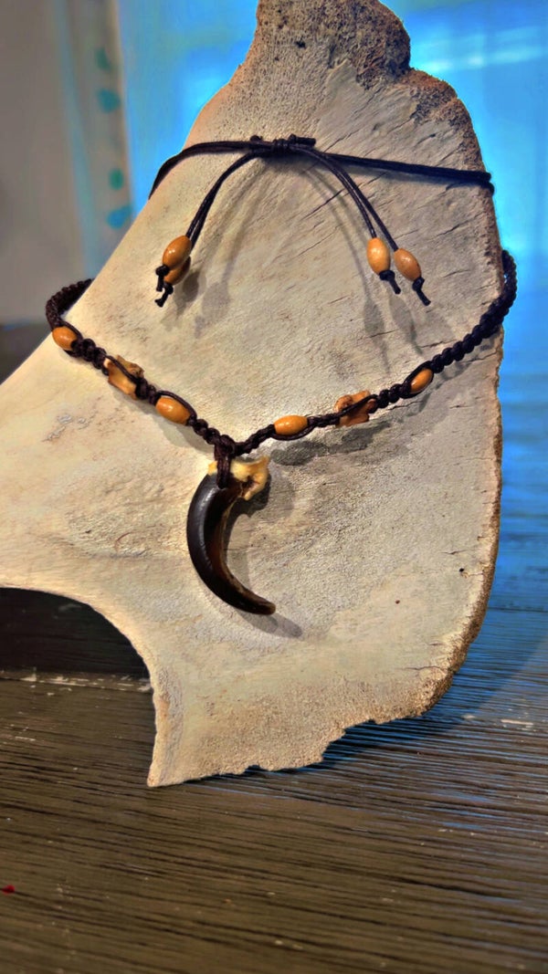 wolf claw necklace adorned with snake vertebrae beads.
