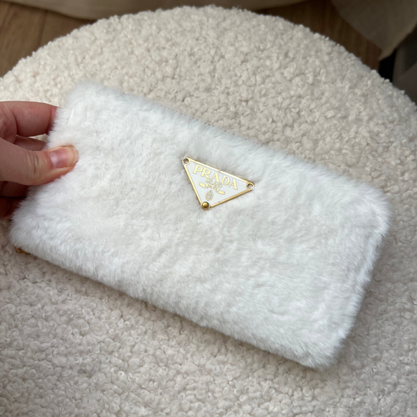Authentic Prada tag - sewed on a fluffy white wallet.