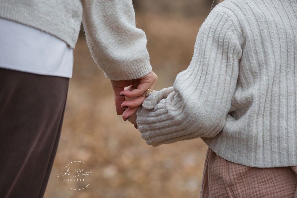 Mutter und Tochter halten Händchen - Clos-Up von hinten.
