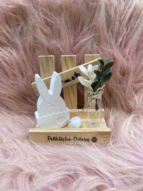 Osterhase am Zaun mit kleiner Vase