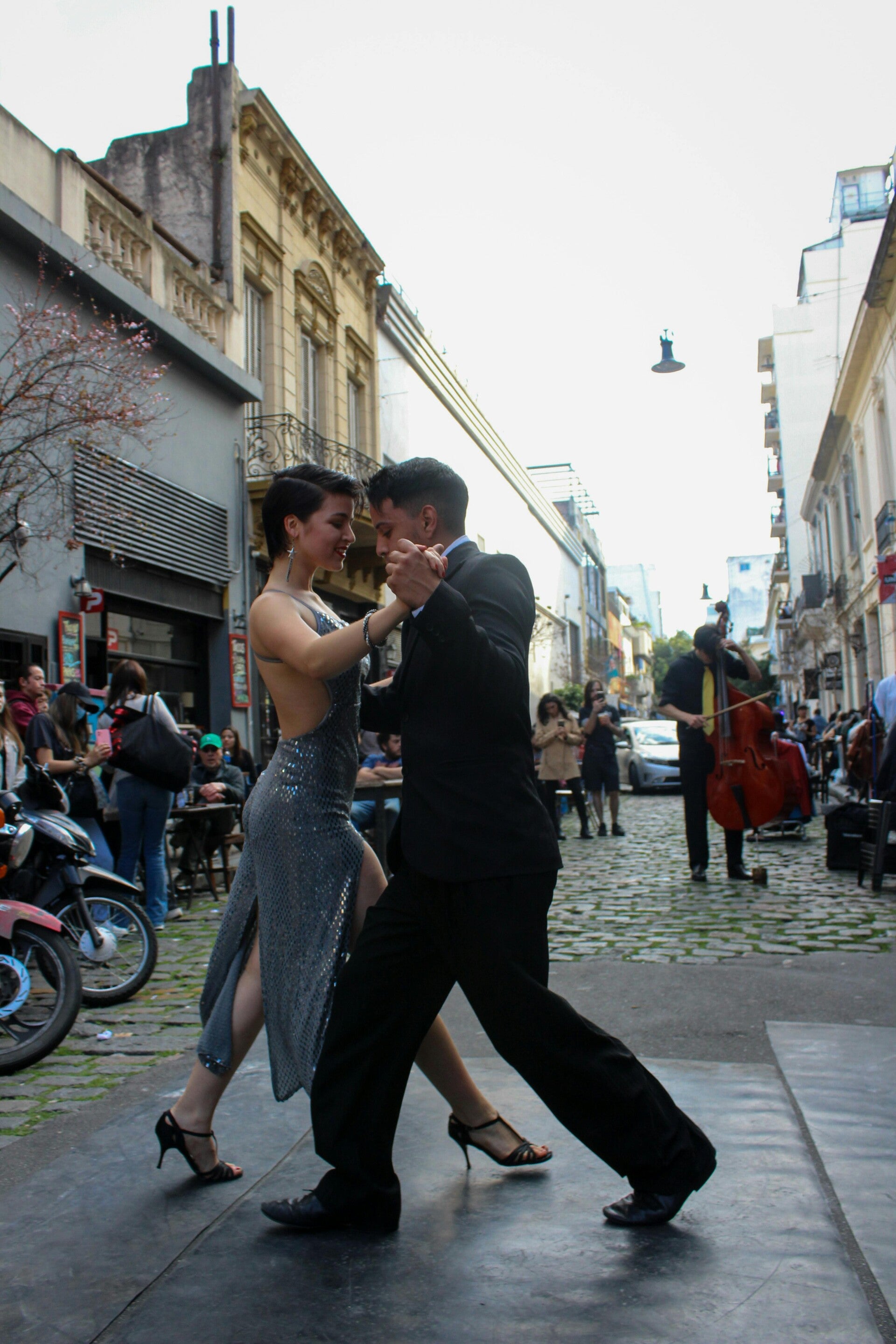 Couple dansant le tango argentin dans une rue de Buenos Aires, avec un bandonéon en fond
