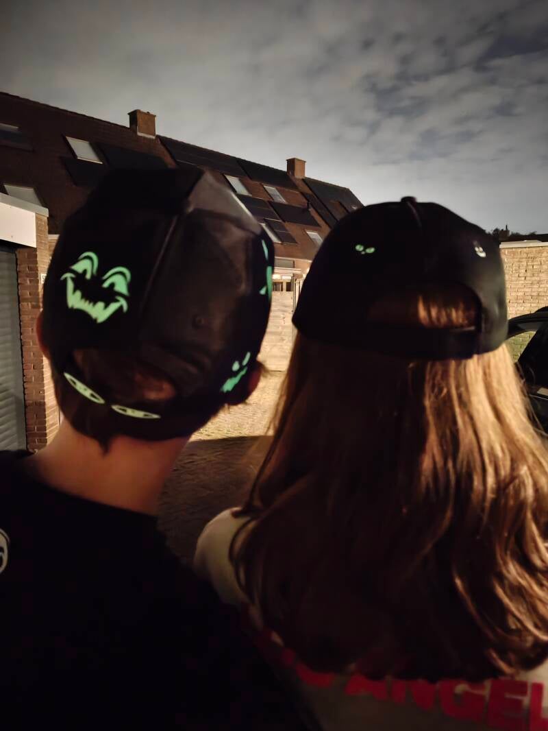 Zwarte Halloween caps met glow-in-the-dark details aan de achterkant, handbedrukt door LIAN Studio