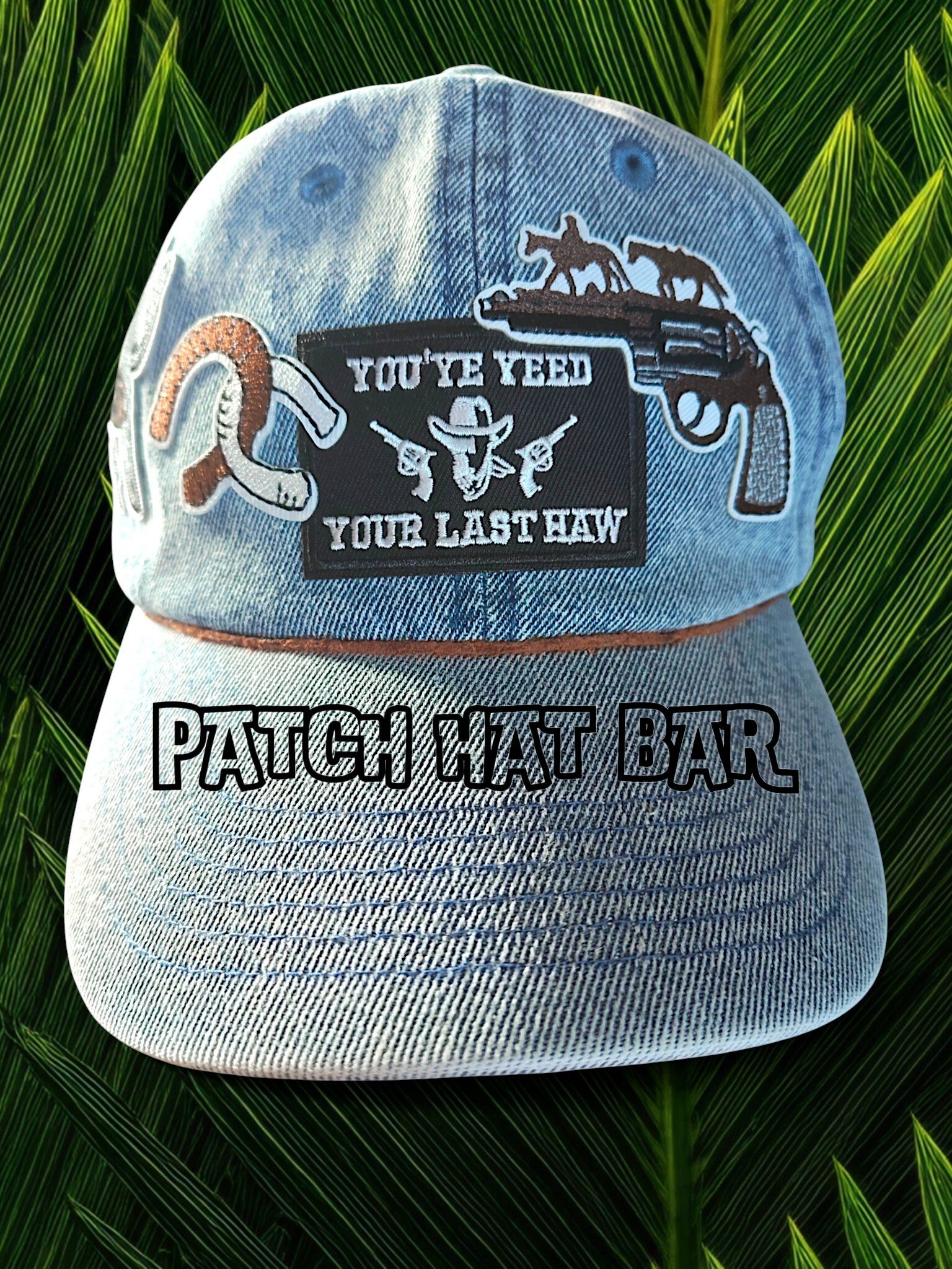 Cowboy western stijl cap van denim materiaal met 4 cowboygerelateerde patches in de kleuren zwart, wit, bruin. Over de klep loopt een leder (lasso)bandje voor extra pit
