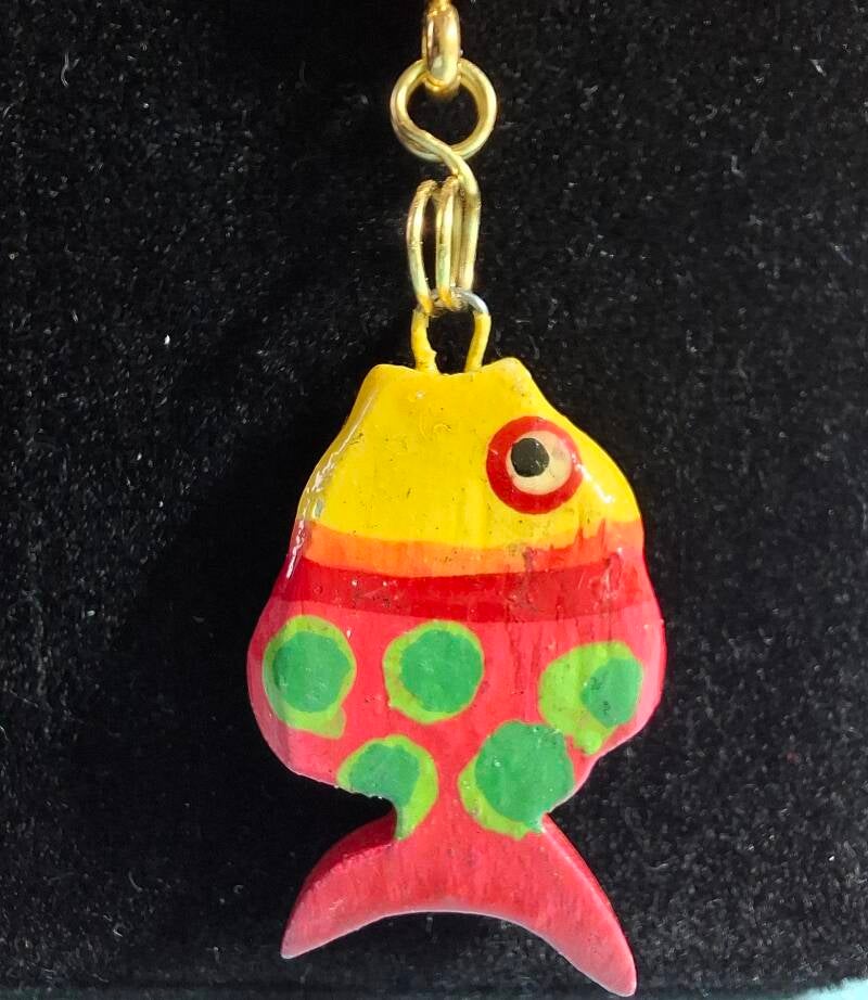 Close up houten vis hanger bij Sunset ketting