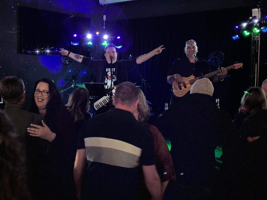 Guests dancing while Rick Toner performs live music at a Hawke's Bay birthday party