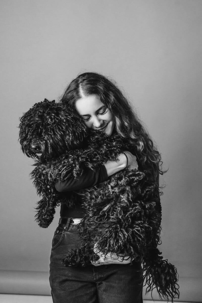 Portrait of a woman hugging her dog