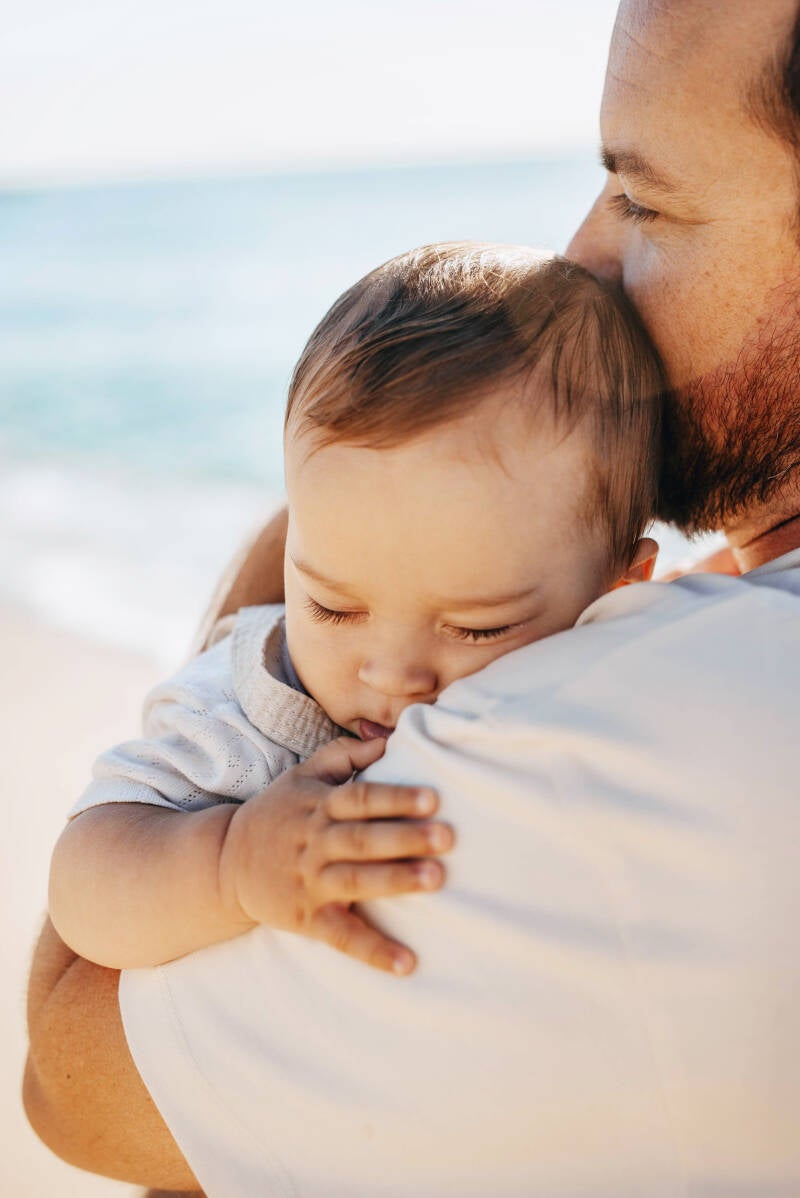 Portrait of a father holding his newborn child