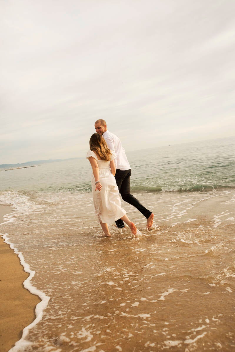Natural couple portraits with sea and waves in the background