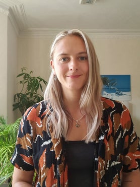 Georgie Simmons, a qualified counsellor and psychotherapist, smiling warmly in her Bristol-based therapy office.
