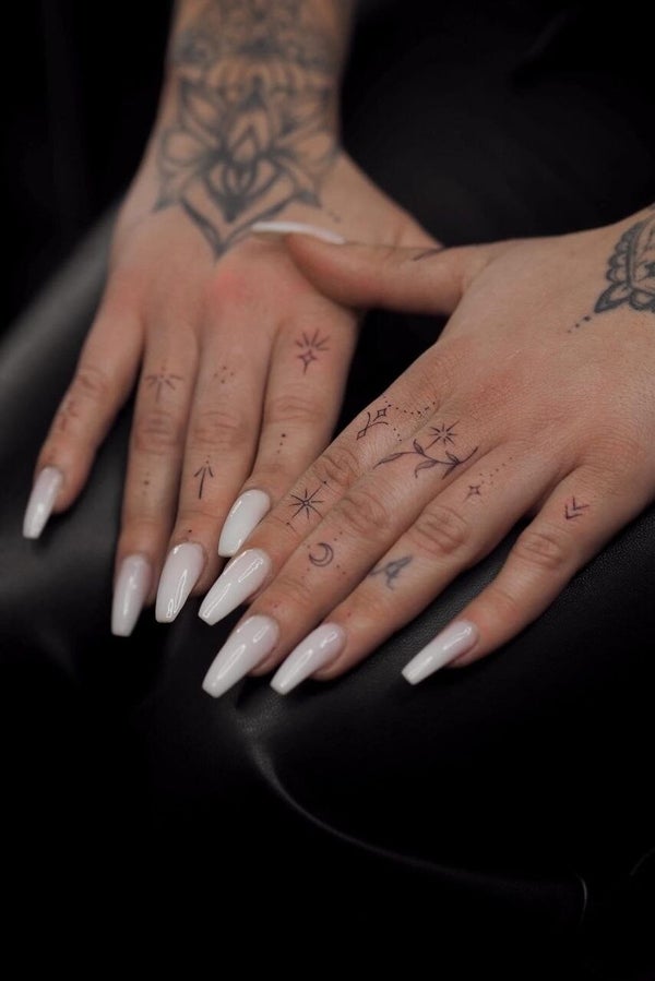 Filigrane Finger-Tattoos und Hand-Tattoos von Hailee Summer mit minimalistischen Symbolen.