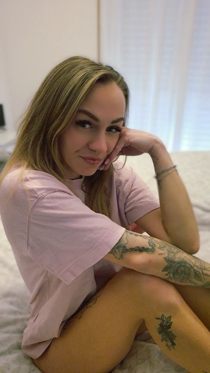 Jessielie – blondes Tattoo Model mit Tattoos am Arm im natürlichen Indoor Setting im entspannten Look